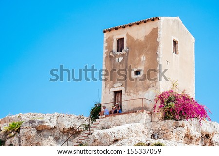 SYRACUSE, ITALY Ã¢Â?Â? JULY 17: Tourists rest in the shade of a building above the Greek theater on July 17, 2013 in Syracuse, Italy. This 2700 year-old Sicilian town is a popular tourist destination.