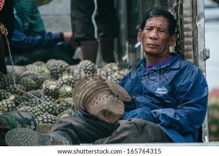 PRANBURI, THAILAND Ã¢Â?Â? FEBRUARY 17: A tired farmworker rests on a truck bed with pineapples on February 17, 2013 in Pranburi. Thailand is the world\'s largest pineapple producer.
