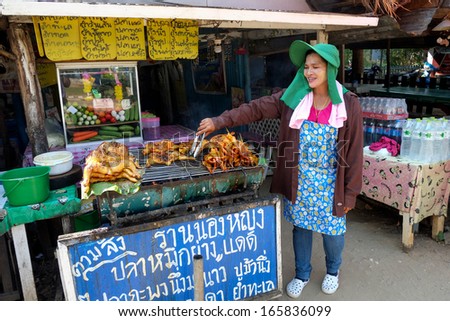 HUA HIN, THAILAND - MARCH 2: Proud Thai woman displays grilled chicken on March 2, 2013 in Khao Kalok south of Hua Hin. Hua Hin is a major tourist destination renown for it\'s food.