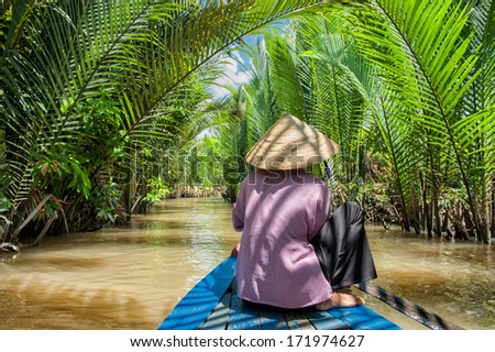 VINH LONG, VIETNAM - MARCH 6: Vietnamese woman paddling a traditional boat in the Mekong delta on March 6, 2009 near Vinh Long. The Mekong river is a major route for transportation in Southeast Asia.