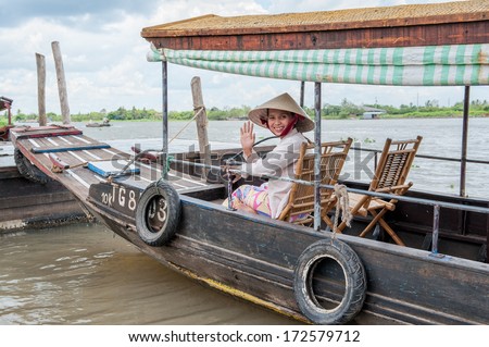 VINH LONG, VIETNAM - MARCH 7: Vietnamese woman sits in a traditional boat on March 7, 2009 in the Mekong delta near Vinh Long. The Mekong river is a major route for transportation in Southeast Asia.