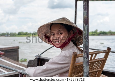VINH LONG, VIETNAM - MARCH 7: Vietnamese woman sits in a traditional boat on March 7, 2009 in the Mekong delta near Vinh Long. The Mekong river is a major route for transportation in Southeast Asia.