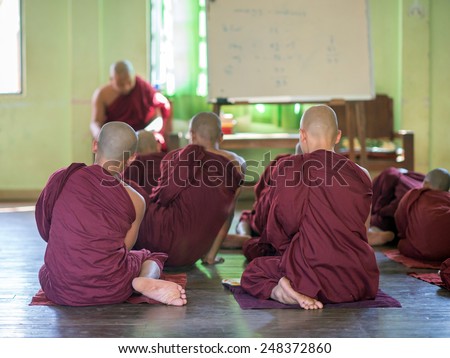 BAGAN, MYANMAR FEBRUARY 8: Young Burmese novice monks and a teacher  in a study room on February 8, 2014 in Bagan. Buddhists in Myanmar belong mainly to the Thervada tradition.
