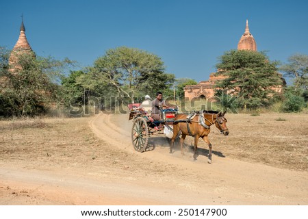 BAGAN, MYANMAR - FEBRUARY 7: Tourist exploring the archeological site on a horse cart  February 7, 2014 in Bagan. Bagan is famous for its thousands of temples, pagodas and stupas.