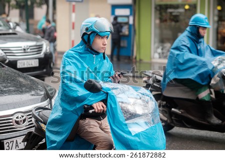 HANOI, VIETNAM   FEBRUARY 11: Young Vietnamese man with a raincoat on a motorbike on February 11, 2015 in Hanoi. There are approximately four million motorbikes on the streets of Hanoi.