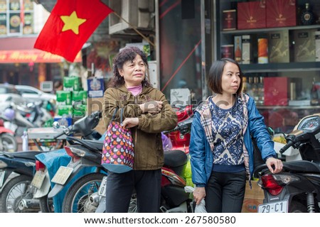 HANOI, VIETNAM - FEBRUARY 15: Two Vietnamese women in the old quarter on February 15, 2015 in Hanoi. The 36 old streets and guilds of the old quarter are a major tourist attraction.
