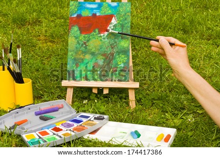 painting with brushes, canvas in a garden