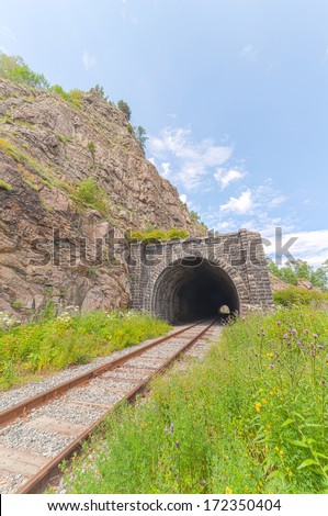The railway tunnel in a rock on the bank of lake Baikal. A landscape