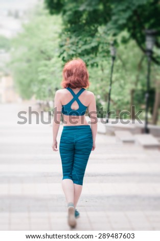 Blurring background slim girl in a park. Slim beautiful body