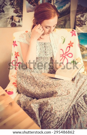 Cute young girl reading a book. Reading the paper book.