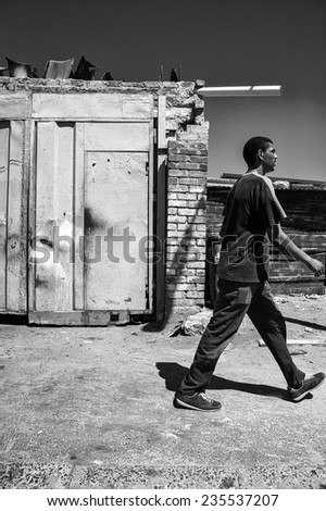 Cape Town, South Africa - circa February 2013, a man walks through a South African township in this black and white image