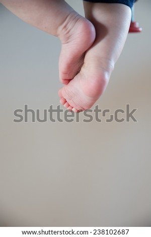 colour image of a childs or babies feet hanging in the air