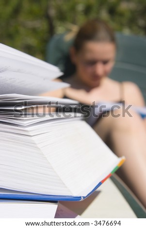young woman reading book outside