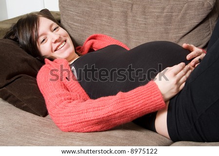 young pregnant woman lying down on the sofa