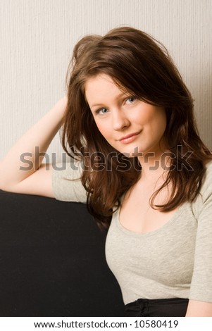 Portrait of young beautiful woman sitting on the sofa