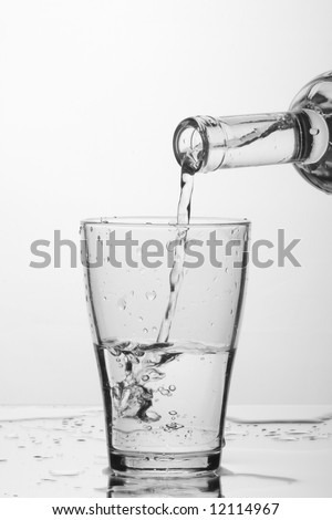 glass of pouring water with reflection (white background)