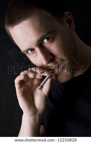 man smoking a cigarette against black background