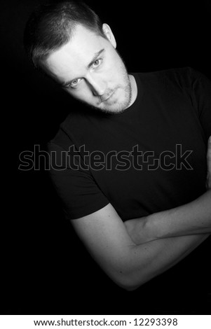 Portrait of a handsome young man in black and white (black background)