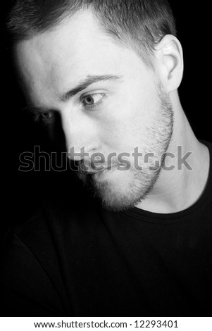 Portrait of a handsome young man in black and white (black background)