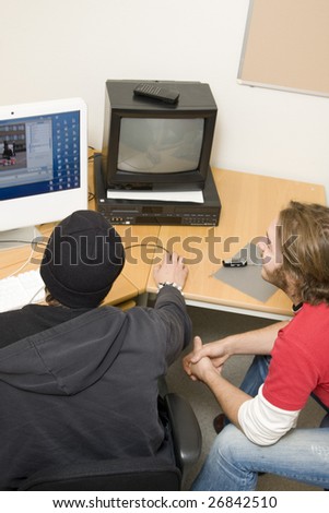 students editing video on computer in classroom