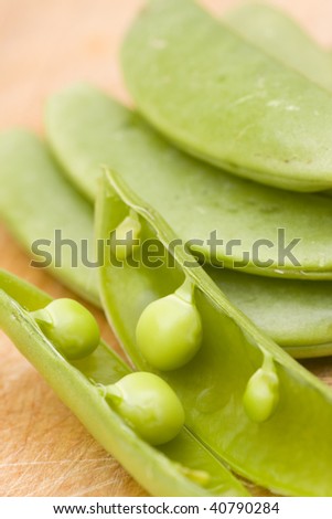 close-up fo opened green bean pod with selective focus on wooden background