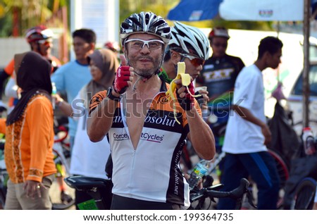 KUANTAN - JUNE 1: unidentified cyclist eating a banana during Kuantan160 on June 1, 2014 in Kuantan, Pahang, Malaysia. KUANTAN160 is a non-profit, non-race 160KM bicycle ride around Kuantan City.