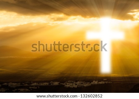 Christian cross glows against the rising sun