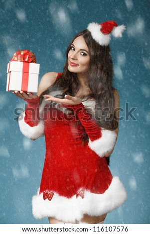 Beautiful  girl wearing santa claus clothes with christmas gift in hand. Christmas concept