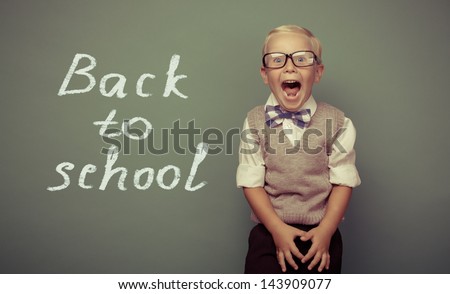 Cheerful smiling little boy on a green background. Looking at camera. School concept
