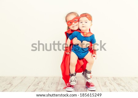 Two funny little power super hero kids in a blue raincoat. Superhero concept