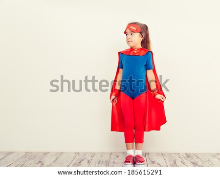 Funny little power super hero kid  (girl) in a blue raincoat. Superhero concept