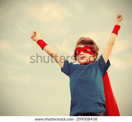 Funny little power super hero child (boy) in a red raincoat. Superhero concept