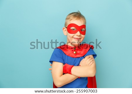 Funny little power super hero child (boy) in a blue raincoat. Superhero concept