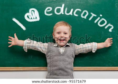 Cheerful smiling child at the blackboard. School concept