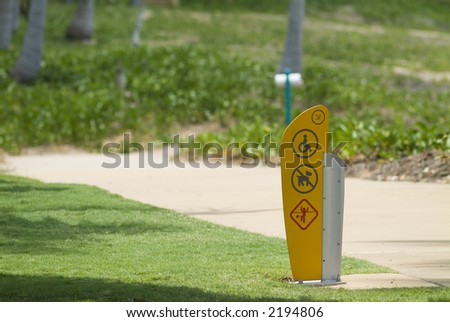 Walking path with sign for wheel chair access, no dogs and stingers in the water.