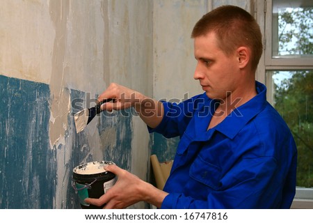 worker repairs a wall in house
