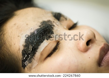 Makeup eyebrow tattooing, pretty asian woman face closeup