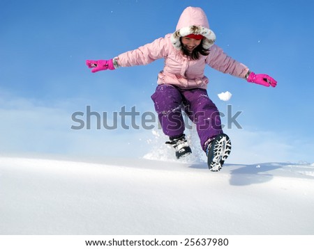 Young girl running down snow bank.