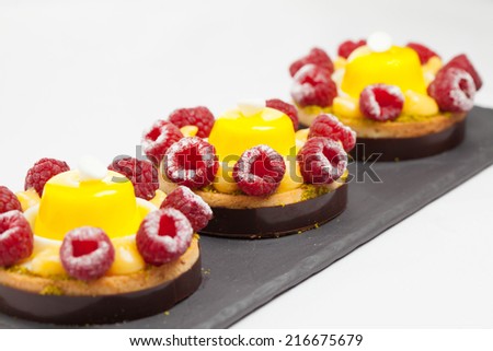 cakes with jelly and raspberry on a black plate