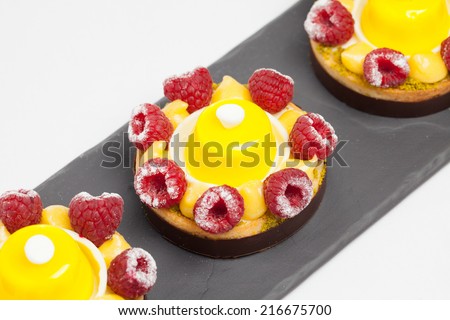 cakes with jelly and raspberry on a black plate