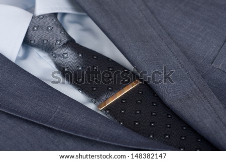 Man suit and tie with gold ties holder