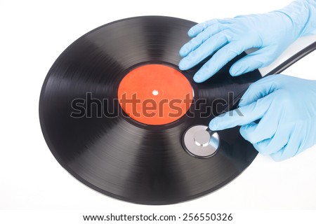 hand with a stethoscope on the surface of a vinyl record