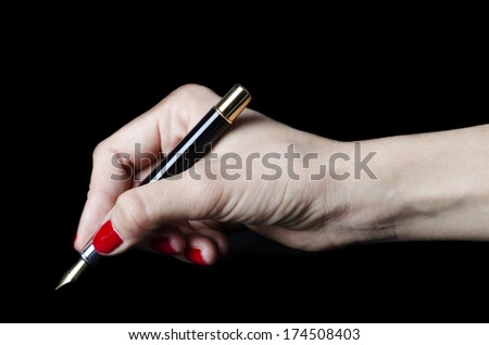 Closeup of woman hand holding pen on notebook isolated on black background