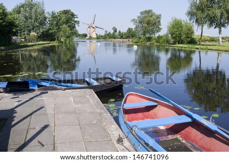 Typical Dutch vista with boats for rent and a mill in Klein Giethoorn in Hazerswoude, Netherlands.