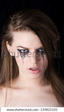 young beautiful woman crying on dark background