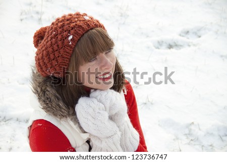 Portrait of pretty smiling young girl in hat and gloves dreaming  and looking up