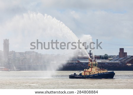 LIVERPOOL, ENGLAND - MAY 25:  Tug boat Svitzer Bidston sprays water on the River Mersey on May 25, 2015 as part of celebrations to mark Cunard cruise line\'s 175th anniversary.