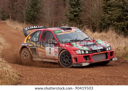 GREYSTOKE, ENGLAND - MARCH 5:  Andrew Burton and Robin Kellard drive their Peugeot Cosworth to victory in the 2011 Malcolm Wilson Rally on March 5, 2011 in Greystoke Forest, England.