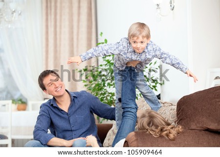 Parents play with his son, he depicts flying the plane
