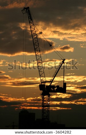 Lifting crane at sunrise with filter.
